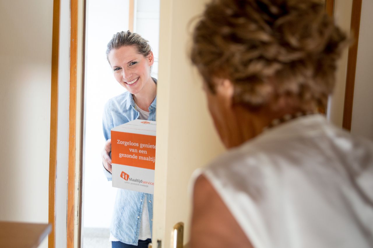 Bezorger van maaltijdservice.nl levert aan huis bij oudere